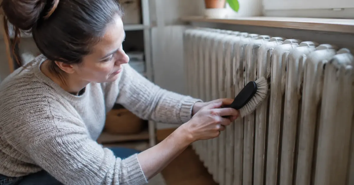 Main frottant radiateur fonte horizontalement avec brosse