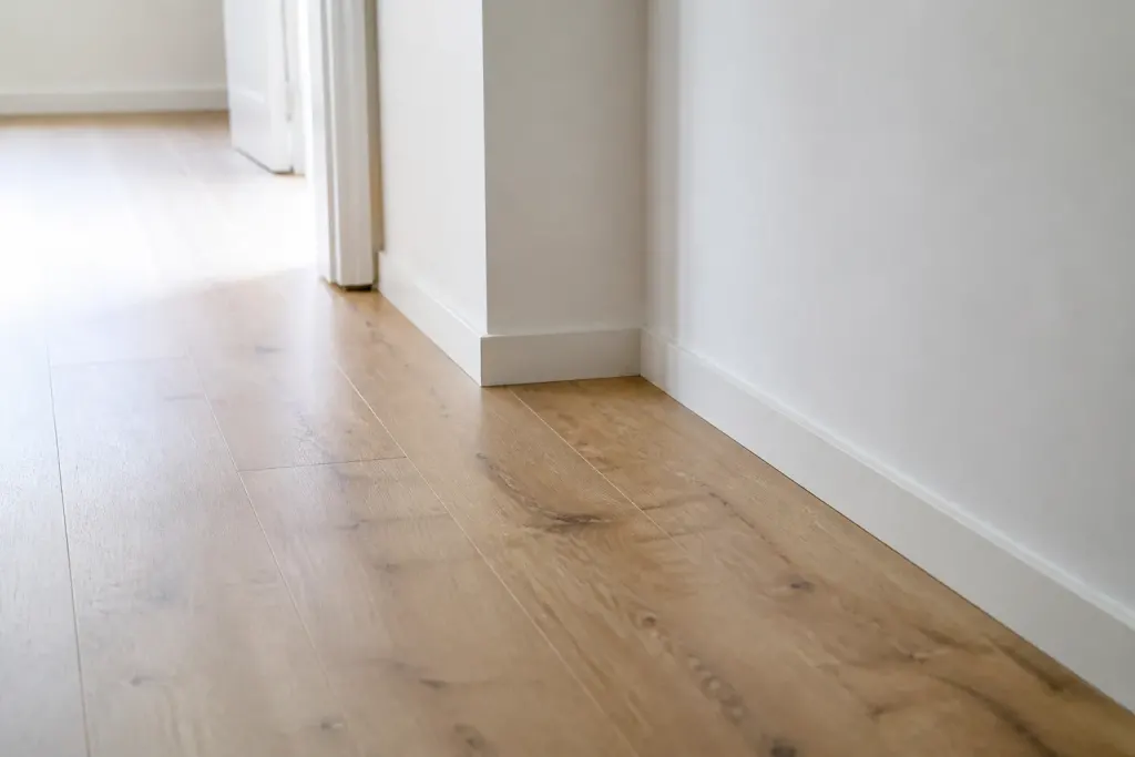 Revetement sol stratifie avec plinthes blanches